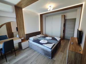 ヴァルナ・シティにあるEuroproperties SkyLine Apartmentsのベッドと机とテレビのある寝室 +20枚の写真