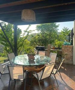 ein Glastisch und Stühle auf einer Terrasse in der Unterkunft Emmanuel villas luxury in Puerto Plata