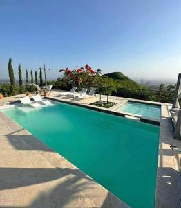 ein großes Schwimmbad mit Liegen in der Unterkunft Emmanuel villas luxury in Puerto Plata