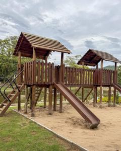 a wooden playground with a slide in a park at Hotel Fazenda RosaBlue in Presidente Getúlio