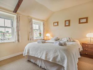 a bedroom with a large bed and two windows at 2 Bed in Salthouse NCC15 in Salthouse
