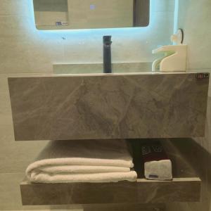 a bathroom with a sink and towels on a shelf at Vayan in Buraydah +12 photos