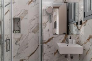 a bathroom with a sink and a shower at Phalerus Suites in Athens +55 photos