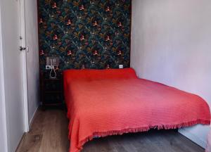 a red bed in a room with a wall at Cozy Seaside Apartment in Cullera in Cullera