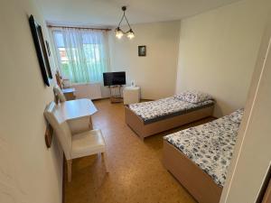 a bedroom with two beds and a desk and a television at Dom Gościnny Danuta in Rewal +29 photos
