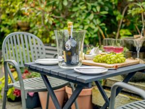 una mesa con una botella de vino y uvas. en 1 Bed in Highcliffe 90444, en Highcliffe 6 fotos más