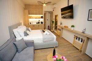 ein Schlafzimmer mit einem Bett und ein Wohnzimmer mit einer Couch in der Unterkunft Blisséa in Piräus