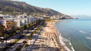 Villa E & M في فلوره: شاطئ فيه نخيل ومباني ومحيط