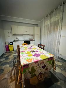 a kitchen with a table with a flowered table cloth at Holiday house daviale in Schisò