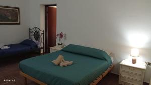 a bedroom with a bed with a green comforter at Casa vacanze di Emilia e Vincenzo in Roggiano Gravina