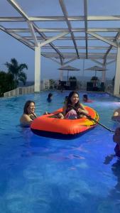 two girls are in the swimming pool in an orange raft at Primavera Cozy studio Condominium, Cagayan de Oro City, Philippines in Cagayan de Oro