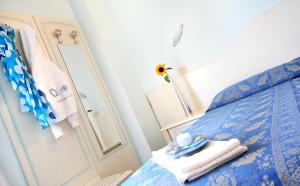 a bedroom with a blue bed and a mirror at Hotel Cadiz in Rimini