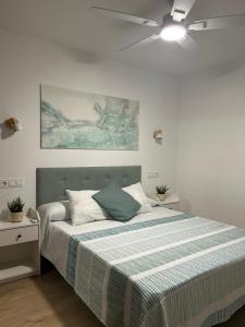 a bedroom with a bed and a ceiling fan at Apartamento Bahía Cullera II in Cullera