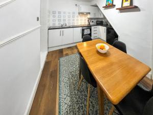 a kitchen and dining room with a wooden table at Beach Oasis Cottage - Uk48530 in Margate