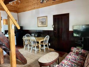 a dining room with a table and chairs at The Elms Waterfront Cottages in Lake Luzerne