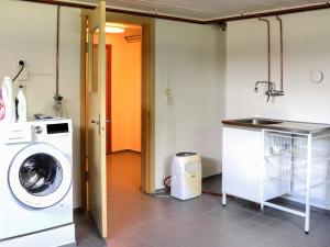 a laundry room with a washing machine and a sink at 4 star holiday home in Förslöv in Förslöv