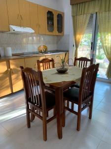 een keuken met een houten tafel met vier stoelen bij Cosyy House in Vlorë