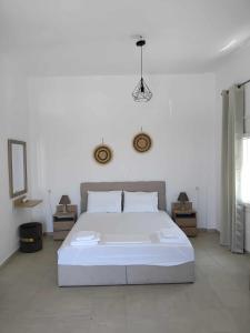 a bedroom with a large white bed in a room at AMPELOS ANDROS in Batsi