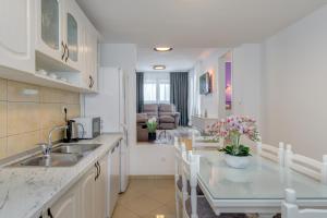a kitchen with a sink and a table with chairs at Apartman Vlasta in Zaglavice +16 photos