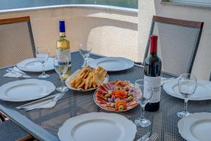 a table with glasses of wine and a plate of food at Apartman Vlasta in Zaglavice