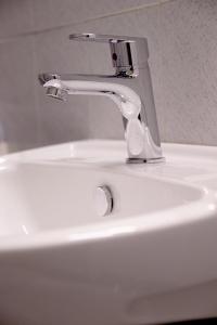 a white sink with a faucet on top of it at Mairyren in Ano Syros