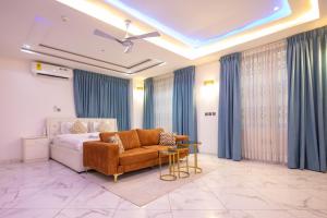 a bedroom with a bed and a couch and a table at Executive Studio Apartment, East Airport in Accra