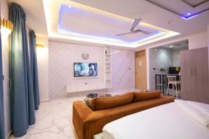 a living room with a couch and a tv at Executive Studio Apartment, East Airport in Accra