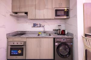 a kitchen with a sink and a washing machine at Executive Studio Apartment, East Airport in Accra