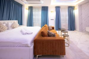 a hotel room with a large bed and a couch at Executive Studio Apartment, East Airport in Accra +15 photos