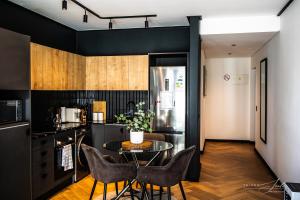 a kitchen with a table and chairs and a refrigerator at KML Nine Palms luxury 101 in Cape Town +31 photos
