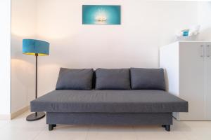 a couch in a living room with a lamp at MADAGÌ Beachfront Apartments in Pozzallo +29 photos