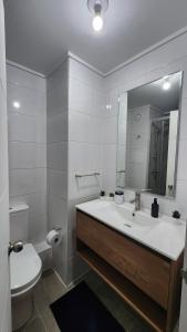 een badkamer met een wastafel, een toilet en een spiegel bij Inmejorable ubicación 2D2B, con estacionamiento in Los Ángeles