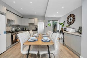a kitchen and dining room with a wooden table and white chairs at Spacious 4BDR House By Homestyles Hosts Short Lets & Serviced Accommodation Suffolk With Private En-Suite & Free Parking in Ipswich