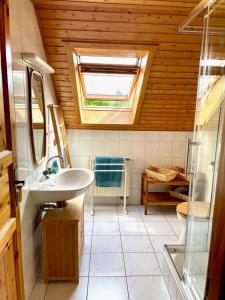 a bathroom with a sink and a window at Ferienhaus Blauvogel 4 in Hasselfelde +20 photos