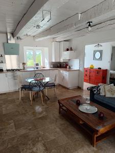 a kitchen and a living room with a table and a couch at Les jardins de Shambhala in Montrem