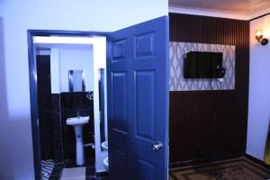 a bathroom with a blue door and a sink at Kairos Guest Lodge Bedfordview in Johannesburg