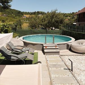 a swimming pool with chairs and a table and a pool at Vikendica Farah in Gaj