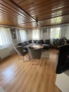 a living room with a couch and a table and chairs at Útulná chaloupka v Krkonoších in Vysoké nad Jizerou