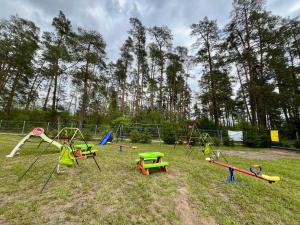 a playground with a bunch of play equipment in a field at Gościniec Wigry 2 in Walne