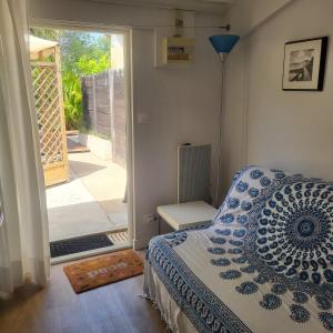 a bedroom with a bed and a door to a patio at Le Mas de la Palmeraie - Studio dans propriété privée au calme avec piscine et tennis in Bormes-les-Mimosas
