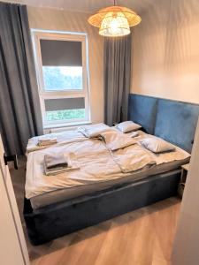 Una cama grande en un dormitorio con ventana. en Luna Apartament, en Rumia