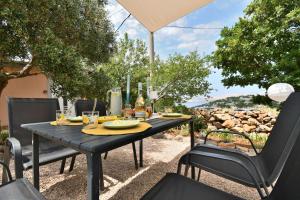a black table with chairs and an umbrella at House Velebit by the sea in Stinica