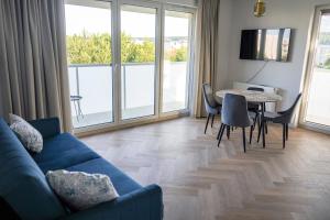 Una sala de estar con un sofá azul y una mesa. en Luna Apartament, en Rumia