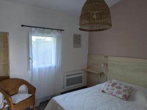 a bedroom with a bed and a chair and a window at Petite Maison Chaleureuse avec piscine in Dolus d'Oléron +23 photos
