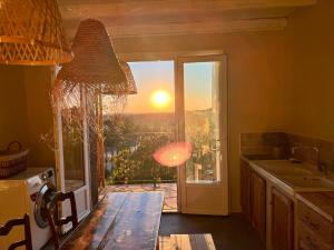 a kitchen with a view of the sunset through a window at Designer townhouse with 2 stunning terraces in Lafrançaise