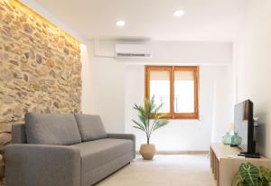 a living room with a couch and a stone wall at Aromes d'Espadà in Eslida