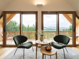 a living room with chairs and a table and a balcony at Die neue Weizerhütte in Sankt Kathrein am Offenegg