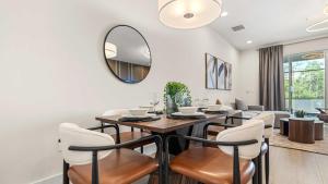 a dining room with a table and chairs and a mirror at Upstay Pristine 3BR Home with Private Pool & BBQ in Orlando