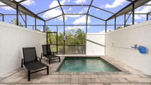 a swimming pool in a glass house with two chairs at Upstay Pristine 3BR Home with Private Pool & BBQ in Orlando