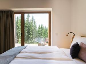 a bedroom with a bed and a large window at Die neue Weizerhütte in Sankt Kathrein am Offenegg